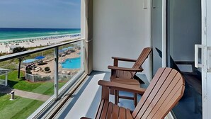 Un balcon avec vue sur une plage et une piscine.