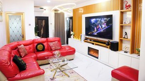 A modern living room with a red sectional sofa, a glass coffee table, a flat-screen TV, and a fireplace. - UTL Homes & Apartments
Brighton Apartment (Ibadan)