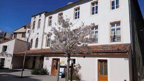 A white building with multiple windows and a tiled roof. - Le Léo Lagrange de Foix (Foix)