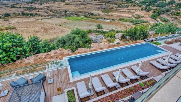 A rooftop pool with lounge chairs and a view of terraced fields. - Stylish Studio • Terrace & Open Views (Rabat)