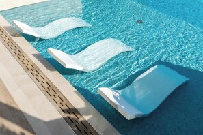 Ein klares, blaues Schwimmbecken mit drei weißen, schwimmenden Absperrungen.