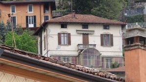 Ein Gebäude mit Ziegeldach, Balkon und einem Fenster mit Rollläden.