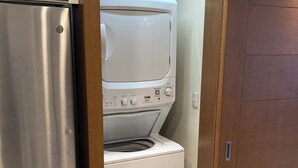 A compact laundry room with a stainless steel refrigerator and a white washer and dryer. - Charming 2BR Resort suites in enchanting San José del Cabo tourist Corridor (San José del cabo)