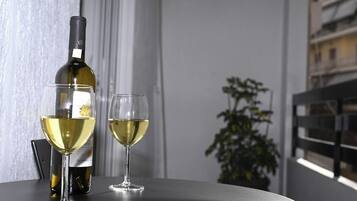 Een fles wijn en twee glazen op een tafel, met een bloempot in de achtergrond.
