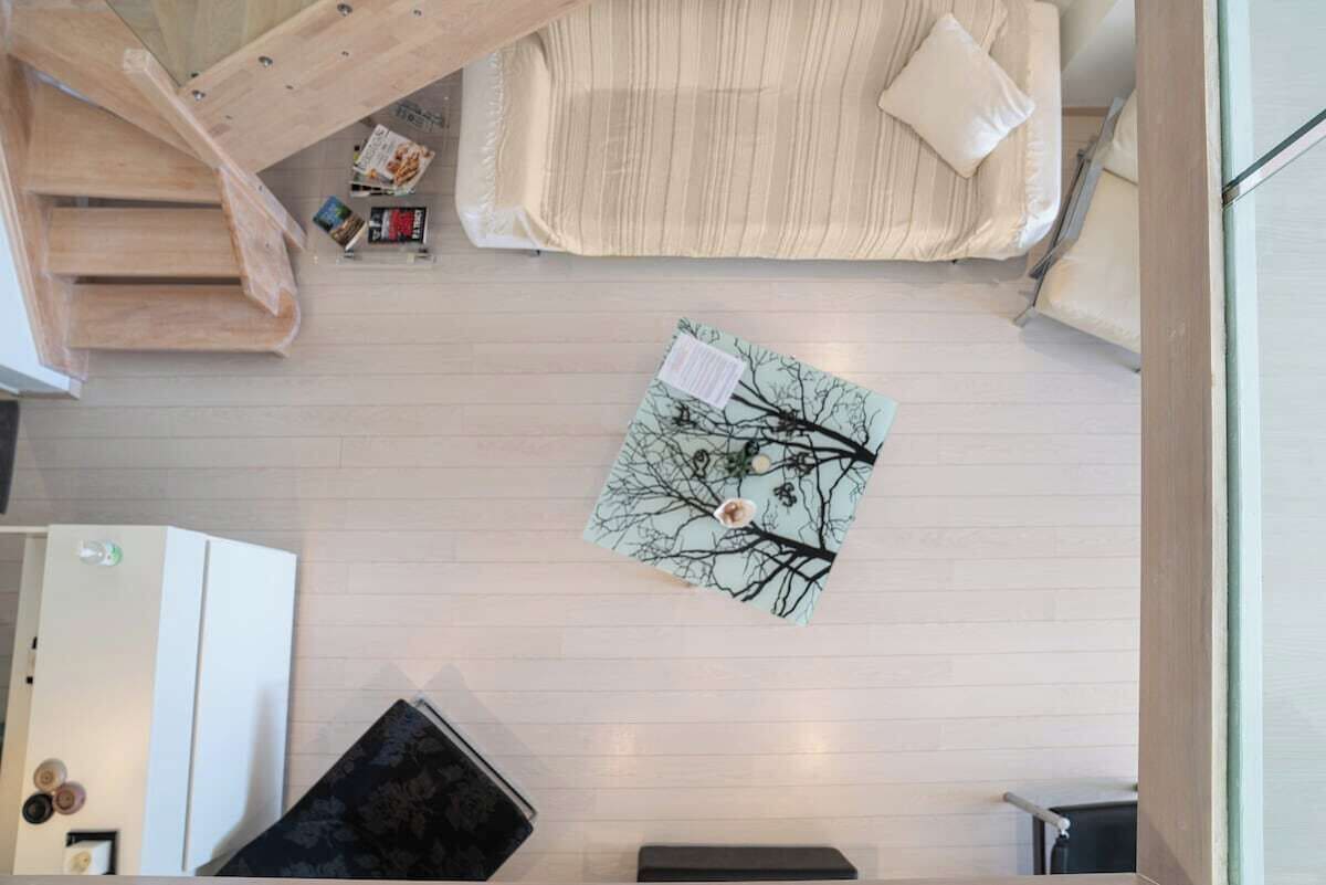 Vue plongeante d’une pièce comprenant un lit, une petite table et une chaise.