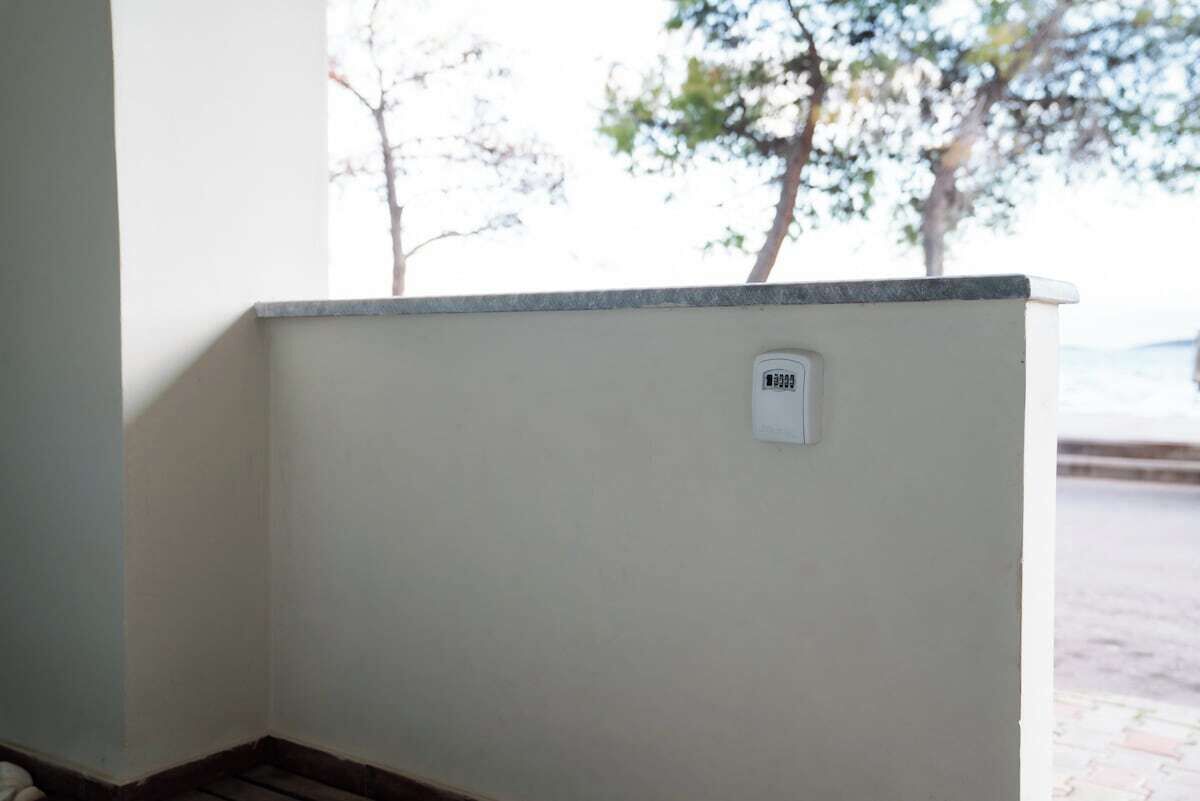 A corner of a room with a white wall and a small window.