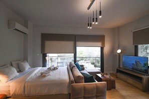 Une chambre d’hôtel moderne dotée d’un grand lit, d’un canapé, d’une télévision et d’un balcon avec vue.