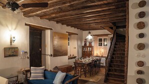 A rustic interior with exposed wooden beams, a dining area, and a staircase. - The 1813 Painter s House by Neuvel (Delphi)