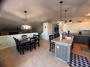 A modern kitchen with a dining area, wooden flooring, and pendant lighting. - Soothing 4-bedroom house with AC in pleasant Billings (Billings)