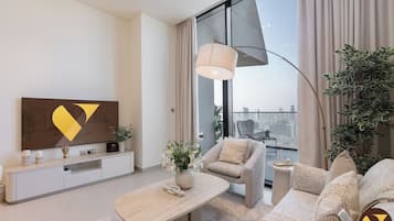 Luksusleilighet, balkong, byutsikt | Oppholdsområde | En 65-tommers smart-TV med kabel-kanaler