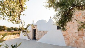 Un bâtiment blanc avec un mur en pierre et une petite entrée.