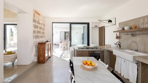 Une cuisine moderne avec un plan de travail en marbre, un saladier rempli de fruits et un four encastré.