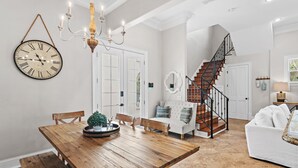 A dining area with a wooden table and chairs, a chandelier, and a wall clock. - 🏖️Private Pool-Pet Friendly-Short Walk to Beach-Villa Palmeira🏖️ (Santa Rosa Beach)
