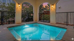 A rectangular swimming pool with a tiled deck, surrounded by black metal railings and a covered patio area with arched ceilings and wall-mounted lights. - 🏖️Private Pool-Pet Friendly-Short Walk to Beach-Villa Palmeira🏖️ (Santa Rosa Beach)
