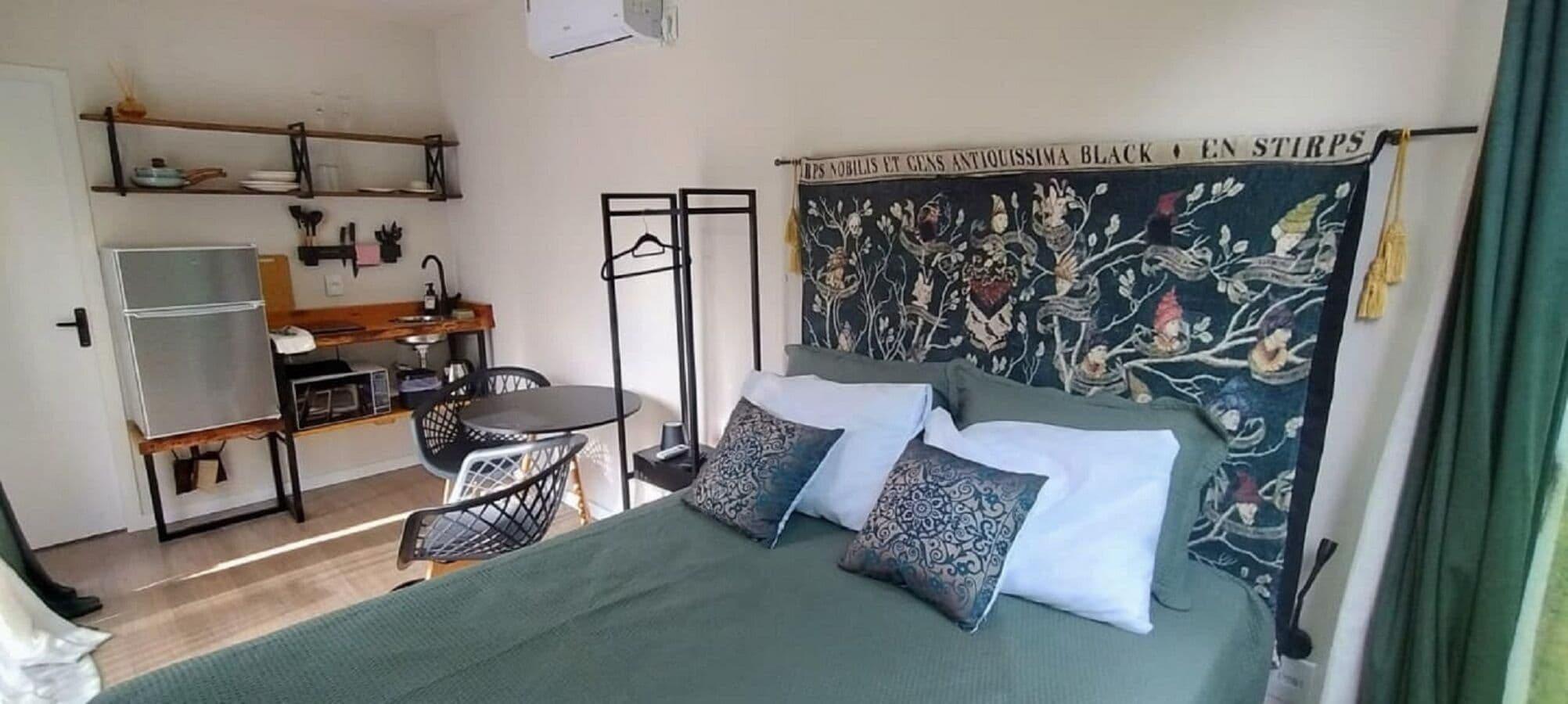 Un dormitorio con cama, almohadas, un escritorio y una silla.