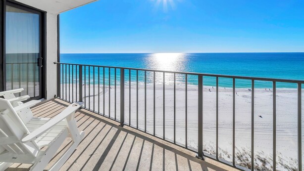 Ein Balkon mit Blick auf einen Strand und das Meer.