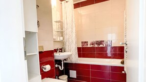 Een badkamer met toilet, wastafel en douche.