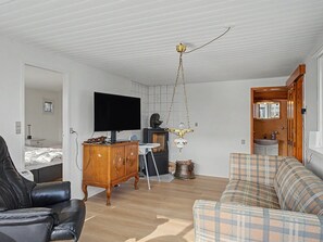 Un salon moderne avec un téléviseur à écran plat, un meuble en bois, un canapé et une cheminée.