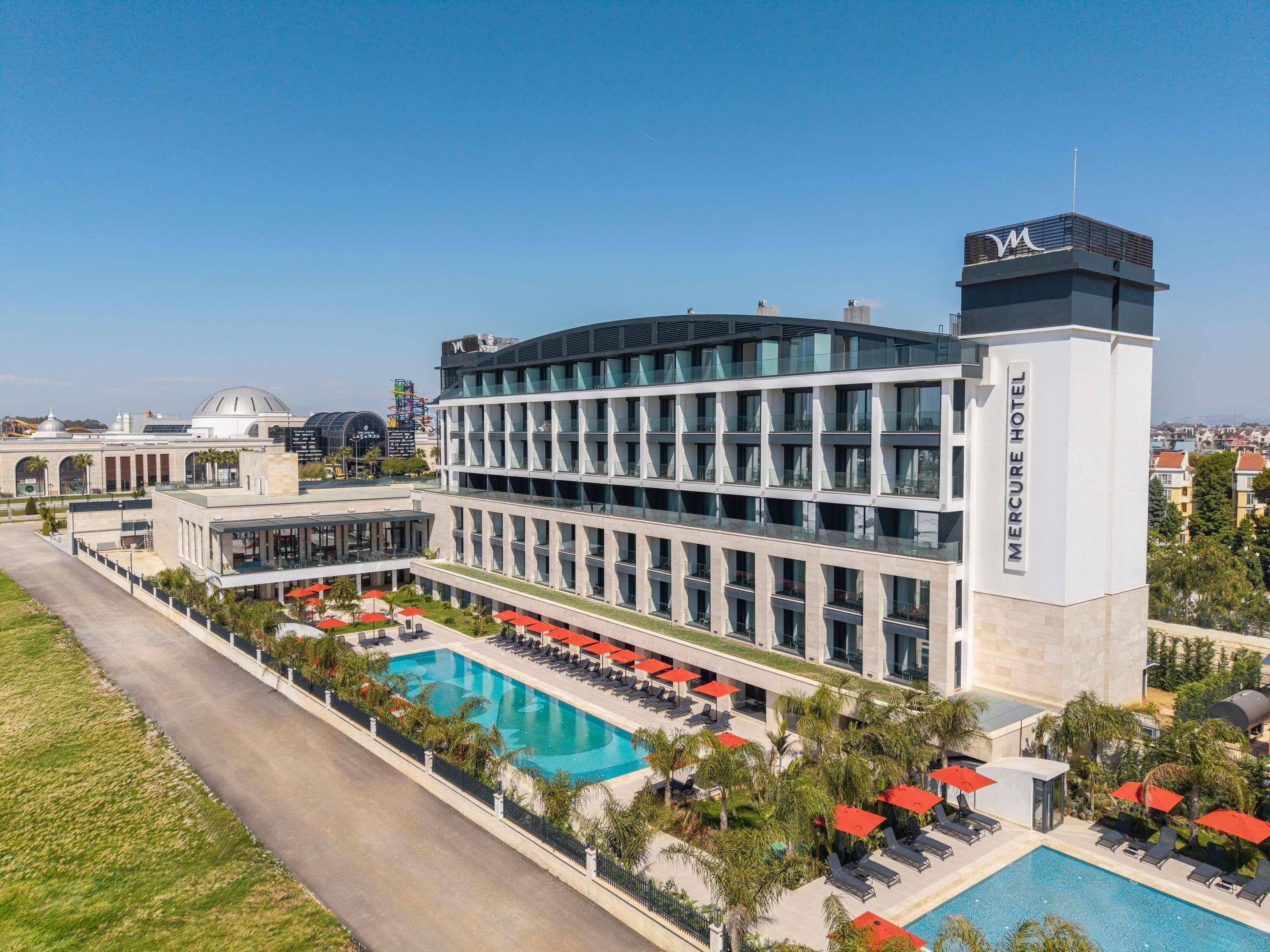 A hotel with a swimming pool, multiple floors, and a prominent 'Mercure Hotel' sign.