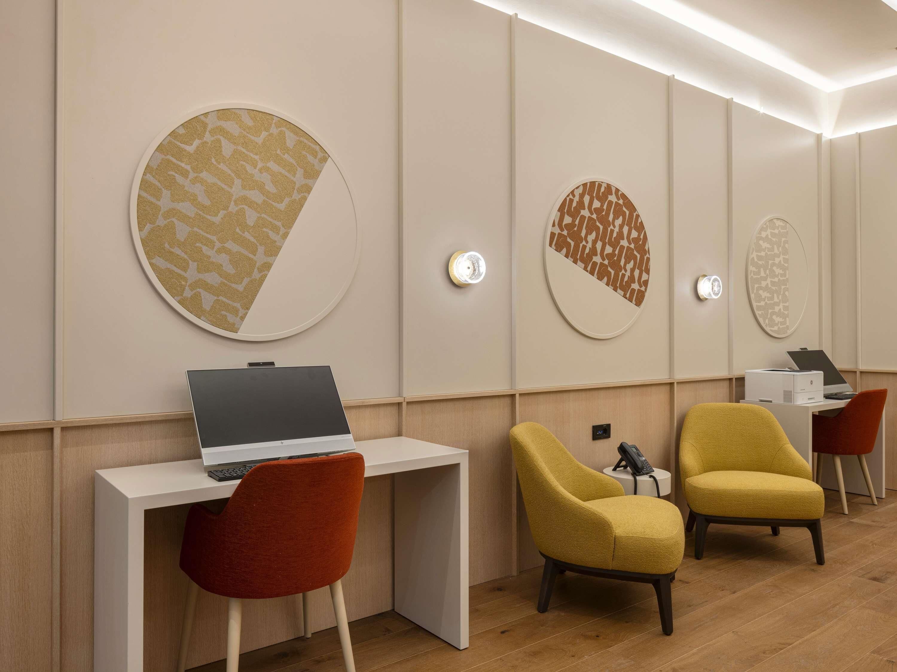 Una habitación moderna con escritorio, dos sillas y una obra de arte en la pared.