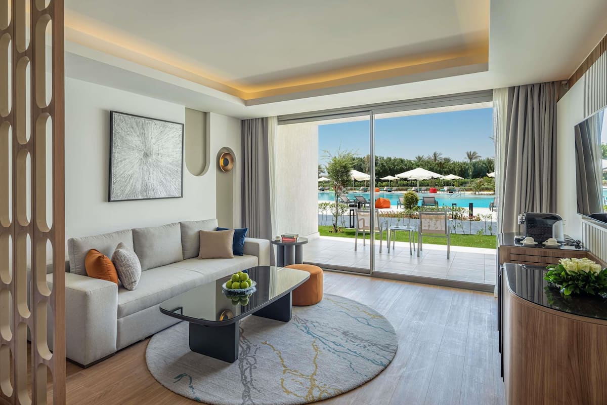 Un salon moderne avec un canapé, une table basse et une vue sur une piscine.