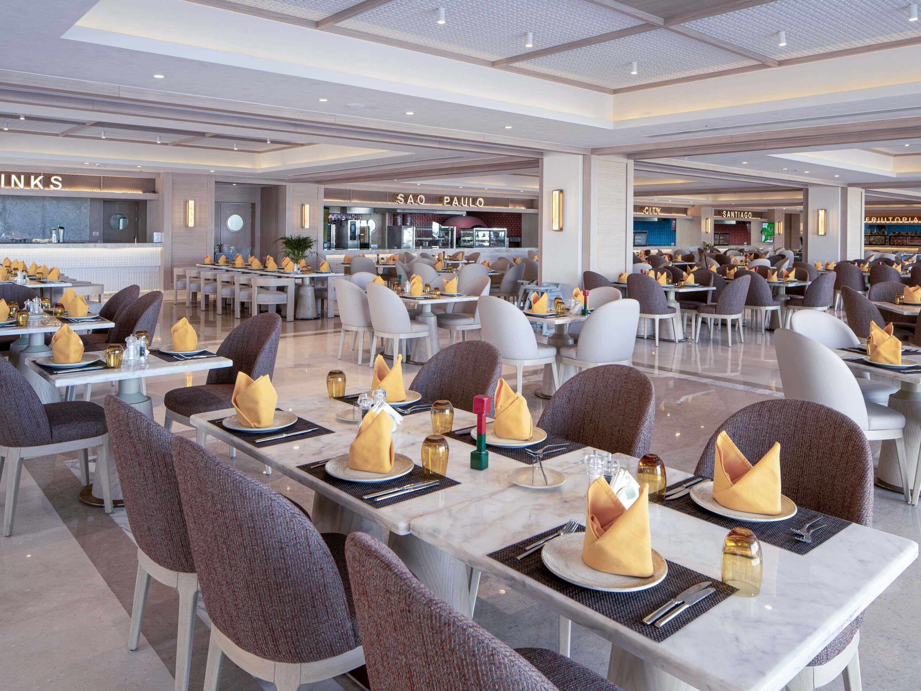 A spacious restaurant with multiple dining tables, each set with chairs and neatly arranged napkins.