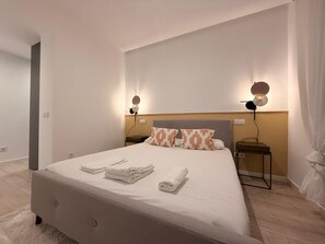 A modern hotel room with a large bed, two bedside tables, and a headboard. - Discover a space designed for comfortable and stylish Madrid living in the heart of Chamberí, one of the city's most authentic and charming neighborhoods. (MADRID)
