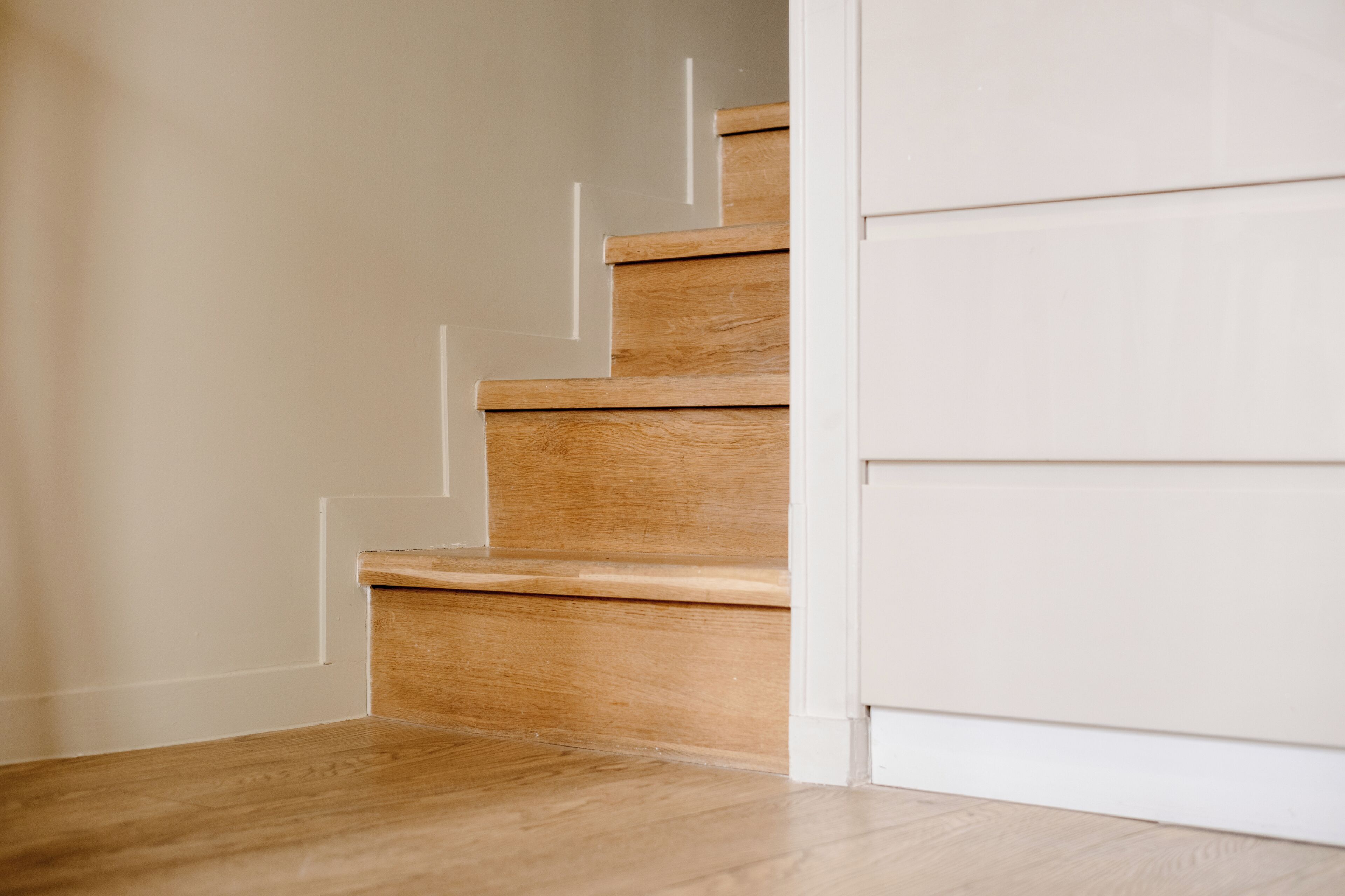 Un escalier en bois, avec des murs blancs et un plancher en bois.