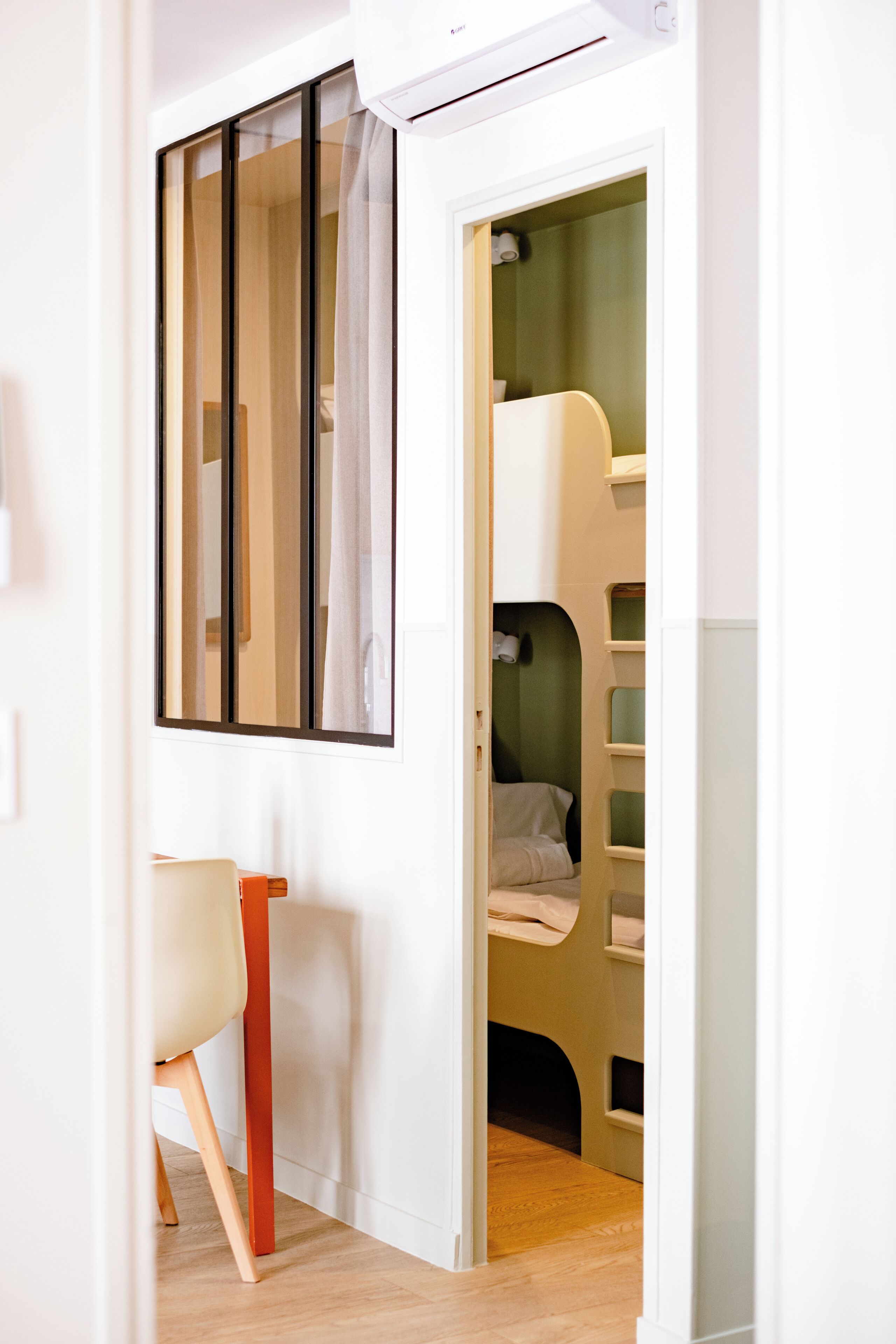 A room with a bunk bed, a desk, and a chair.