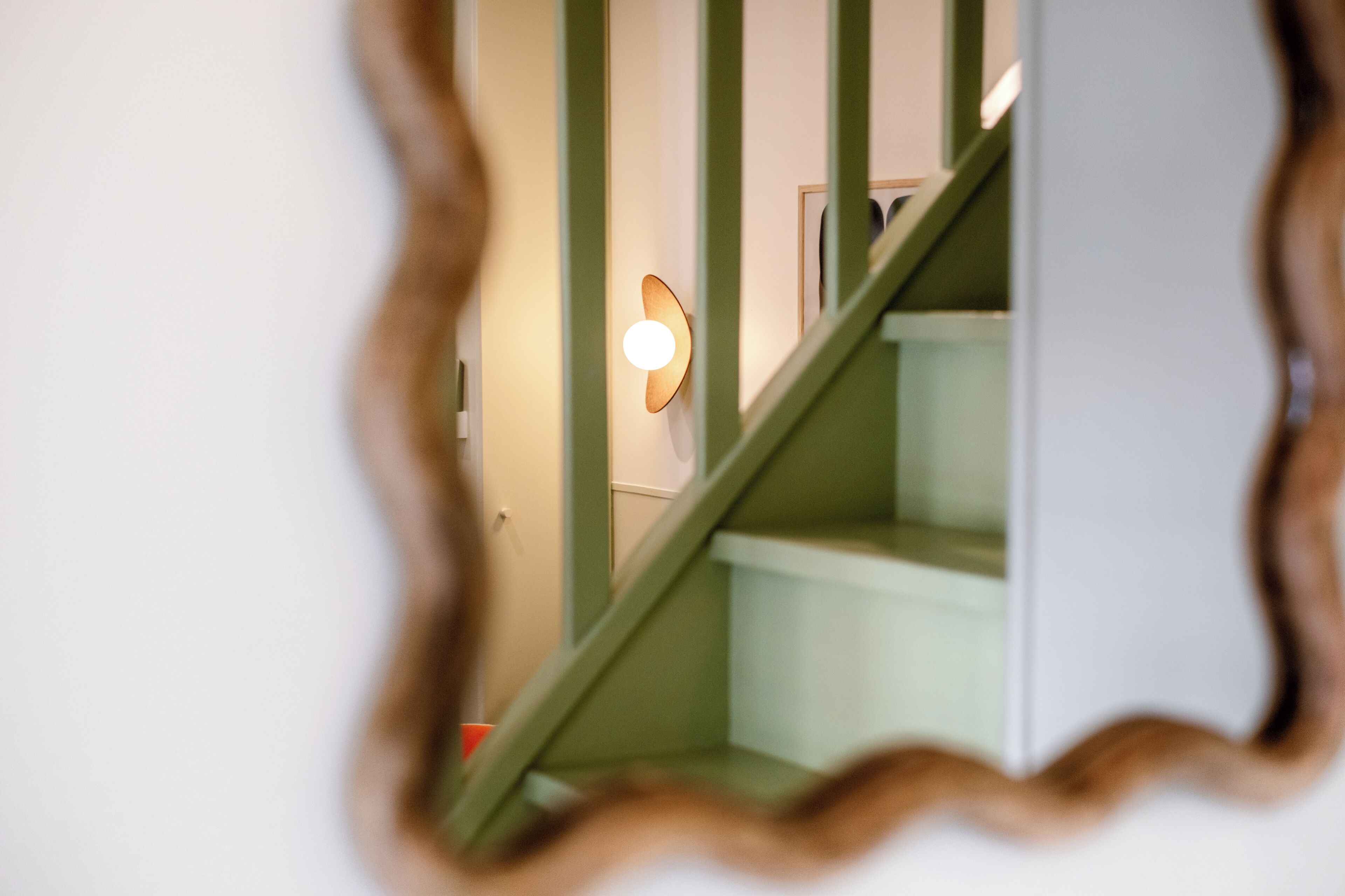 A staircase with a light fixture on the wall.