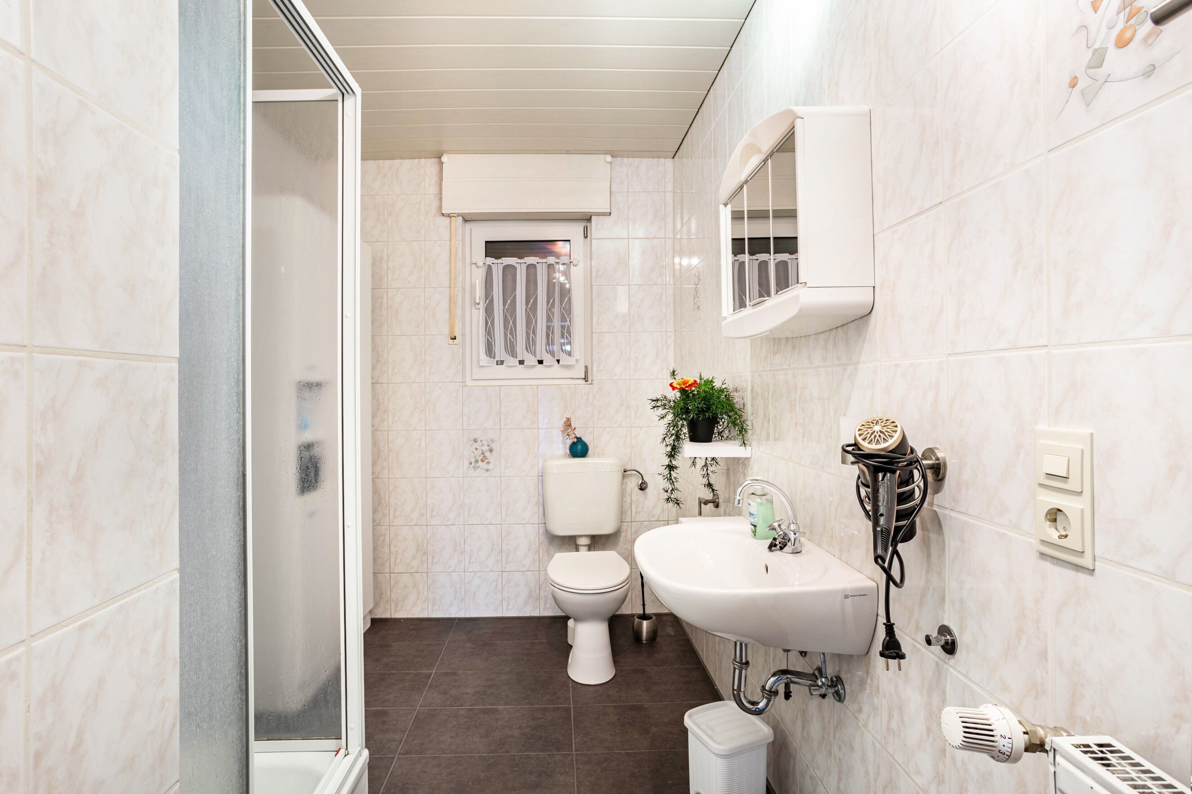 A bathroom with a toilet, sink, and shower.