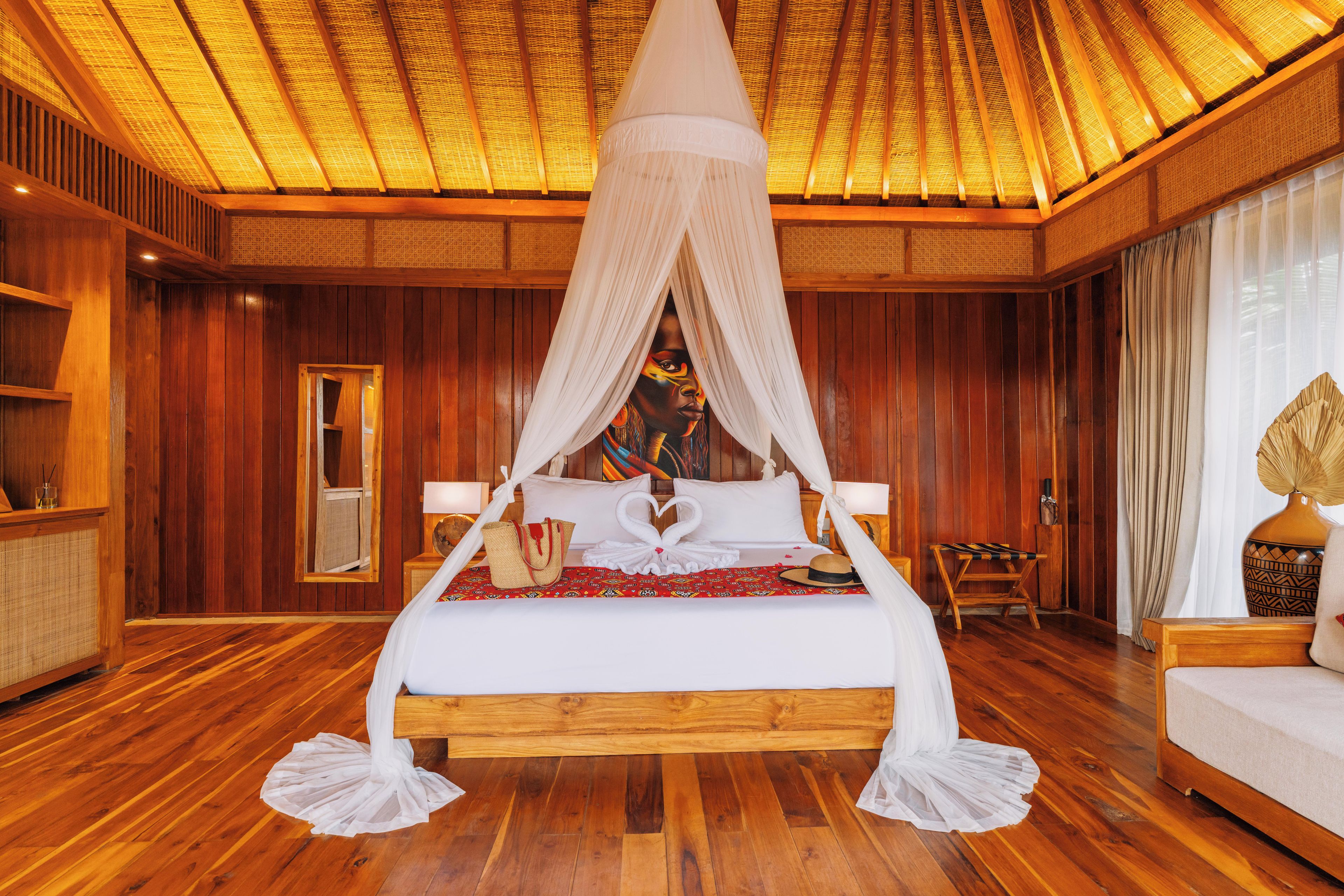 Una cama grande con dosel, paredes de madera y suelo de madera.