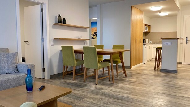 A modern apartment with a dining area, kitchen, and living room.