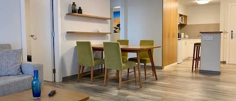 A modern apartment with a dining area, kitchen, and living room.