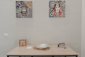 Una habitación con una mesa que muestra obras de arte, un código QR y libros.