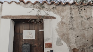 Un bâtiment rustique avec une porte en bois, une boîte aux lettres et une enseigne indiquant « Golden House ».