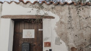 Un bâtiment rustique avec une porte en bois, une enseigne indiquant « Golden House », une boîte aux lettres et un panneau portant le numéro « 4 ».