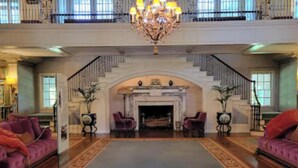 A grand lobby with a high ceiling, a grand staircase, and a large chandelier. - La Casita . (Winston-Salem)