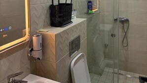 A modern bathroom with a glass-enclosed shower, a vanity with a mirror, and a toilet. - Burj Malaak apartment in a private residence with swimming pool (Marrakech)