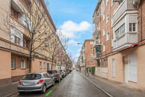 A residential street with parked cars, multi-story buildings, and bare trees. - Dobo Madrid Siena (Madrid)