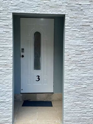 A white door with the number 3, set in a stone-textured wall. - Very Safe Clean Comfortable, Excellent Location
Renovated Townhouse San Fernando (San Fernando)