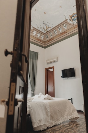 Ein Zimmer mit einem Bett, einem Fernseher und einer Tür.