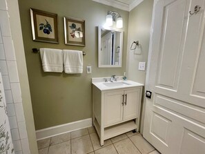 A bathroom with a white vanity, a mirror, and two framed botanical prints on the wall. - Good Ol' Country Farmhouse (Moncure)
