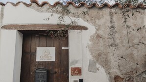 Un bâtiment rustique avec une porte en bois, une boîte aux lettres et une enseigne indiquant « Golden House ».