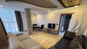 Un salon moderne comprenant un canapé, une table basse, un téléviseur et un coin repas.