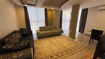 Appartement Deluxe, vue ville | Coin séjour | Télévision