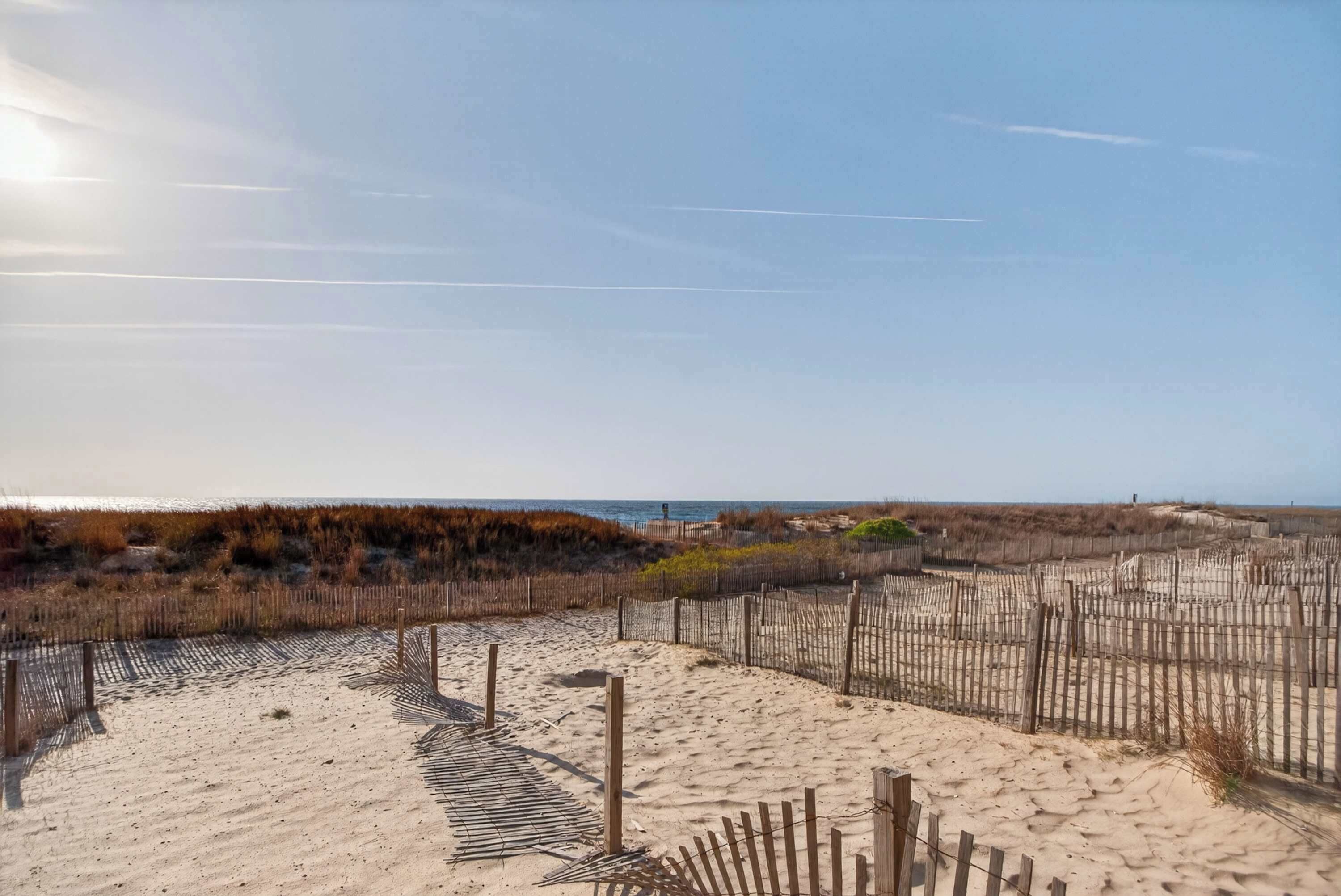 A sandy beach with wooden fences and a clear sky.