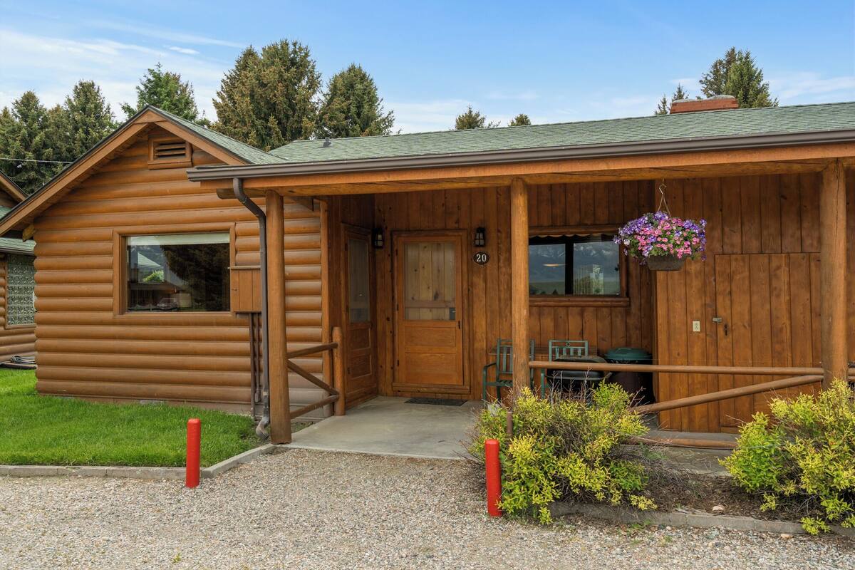 Eine Holzhütte mit Veranda, einer Tür und einem Fenster.
