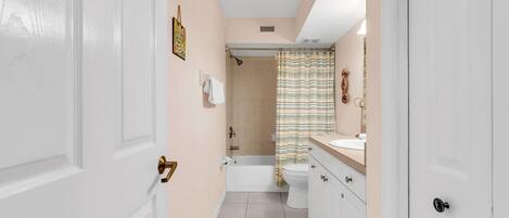 A bathroom with a bathtub, toilet, and sink.