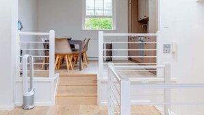 En modern lägenhet med matplats, kök och utsikt genom ett fönster.